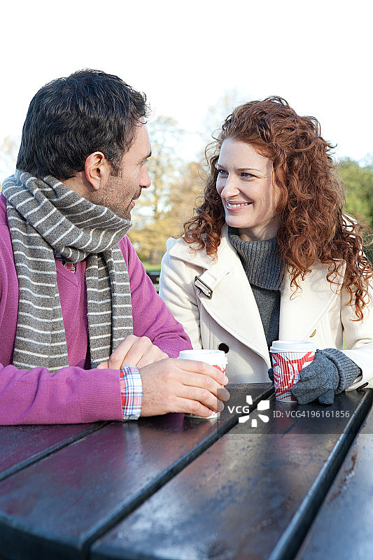 幸福情侣坐在公园桌旁图片素材