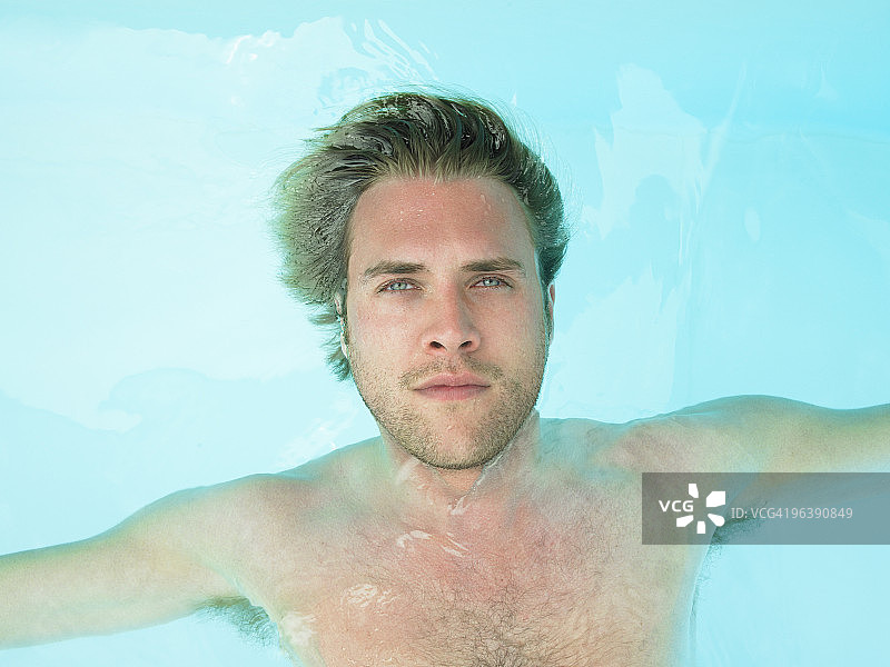 年轻男人漂浮在水中图片素材