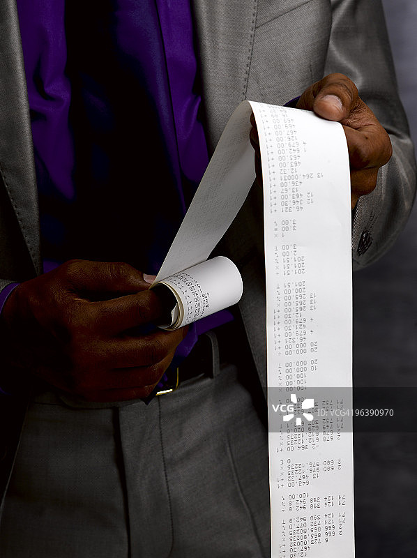 拿着长长的纸质收据的商务人士图片素材