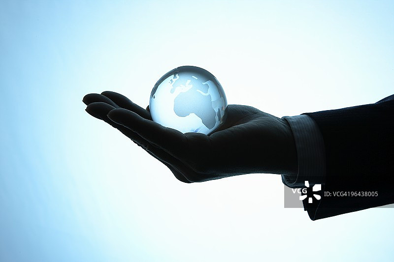 商务人士拿着地球仪，特写图片素材