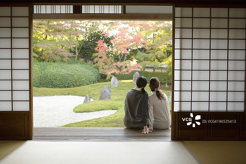 两个女人紧挨着坐在门廊上图片素材