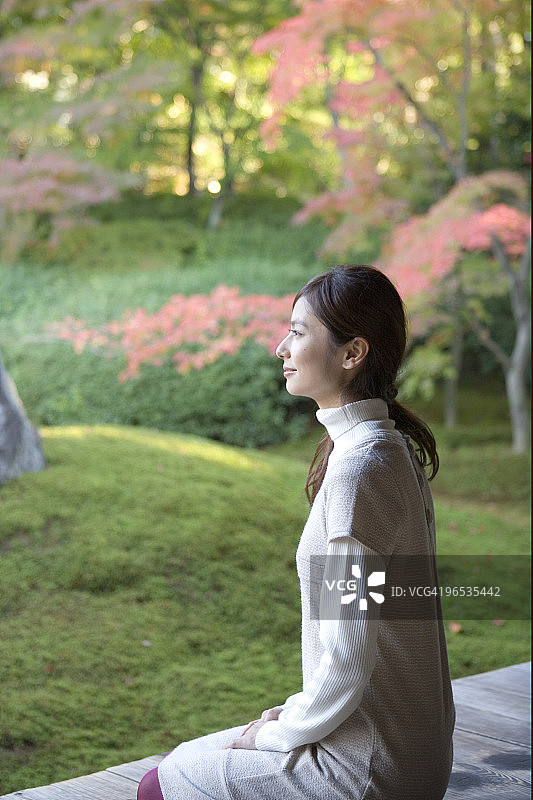 坐在门廊上的年轻女子侧视图图片素材