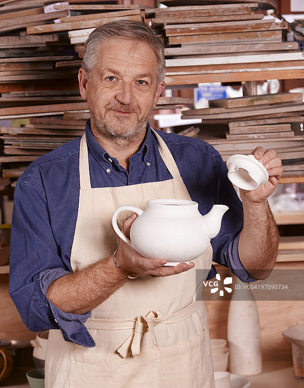 资深陶艺家在工作室制作茶壶图片素材