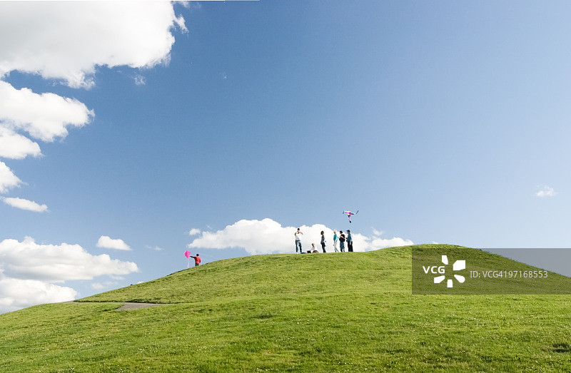 在有蓝天白云的山丘上放风筝图片素材