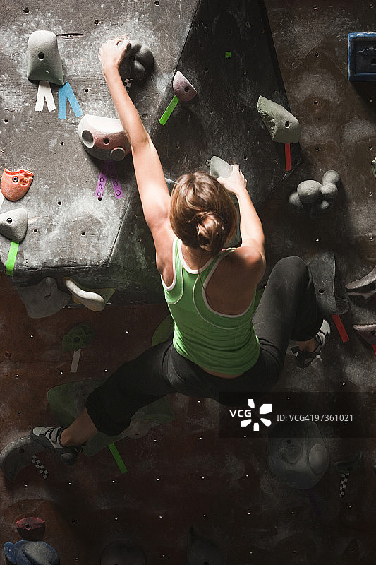 美国犹他州桑迪市年轻女子在室内攀岩墙上图片素材