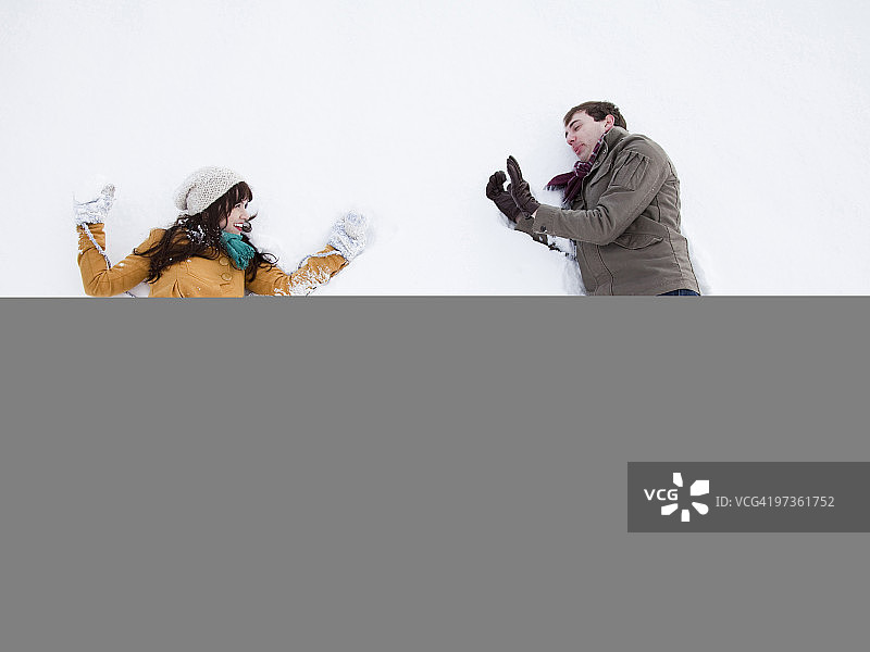 美国犹他州奥勒姆市，躺在雪地里的年轻夫妇图片素材