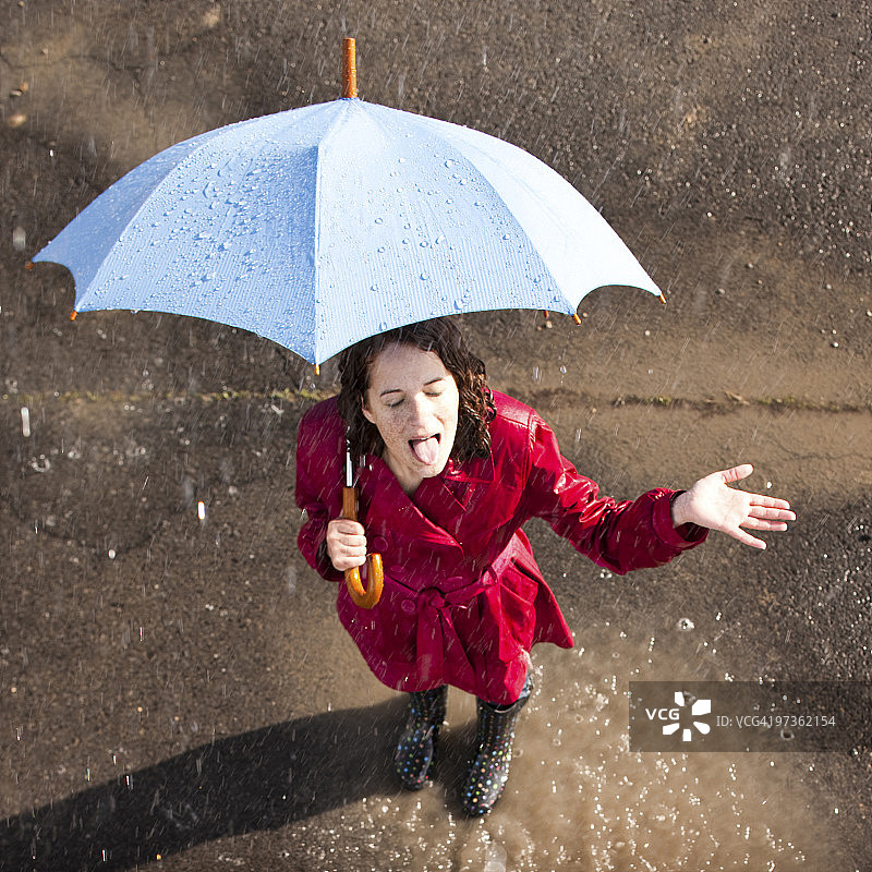 雨中撑伞的年轻女人图片素材