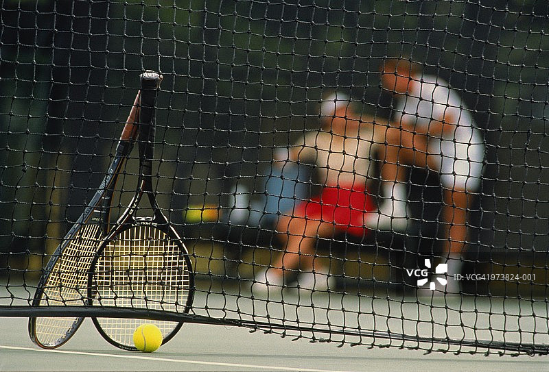球网旁的网球拍和球，球员在后台休息图片素材