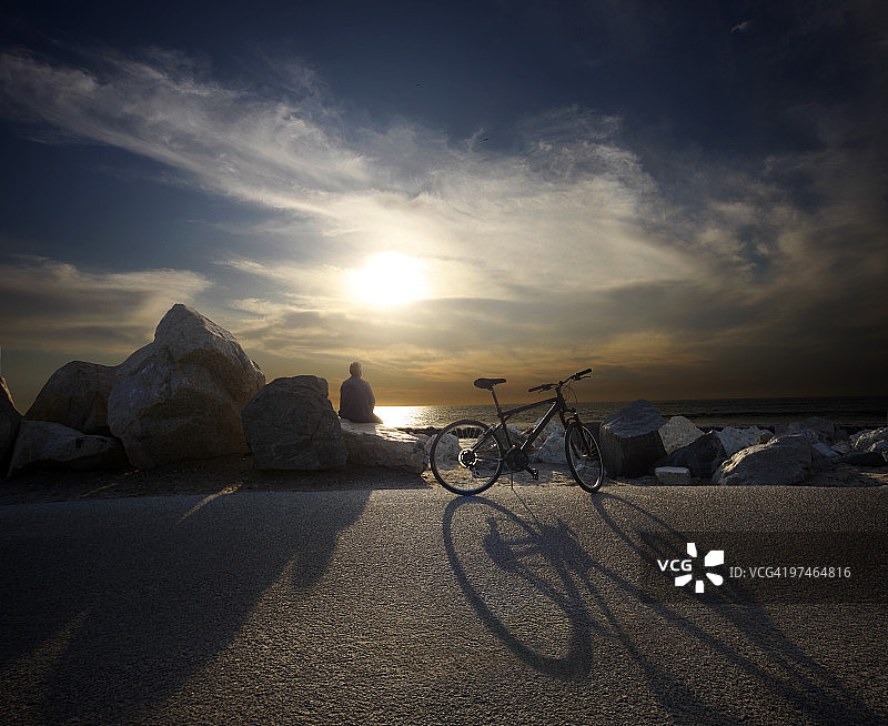 在海滩上看日落的男人图片素材