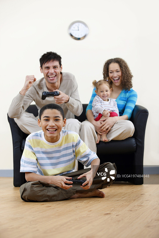 快乐的混血家庭在家玩电子游戏图片素材