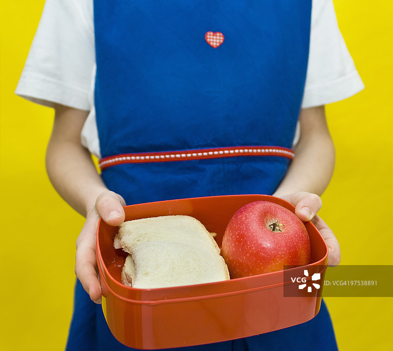 孩子拿着装有健康食品的午餐盒图片素材