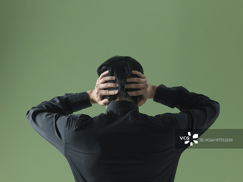 双手抱头的年轻男人图片素材