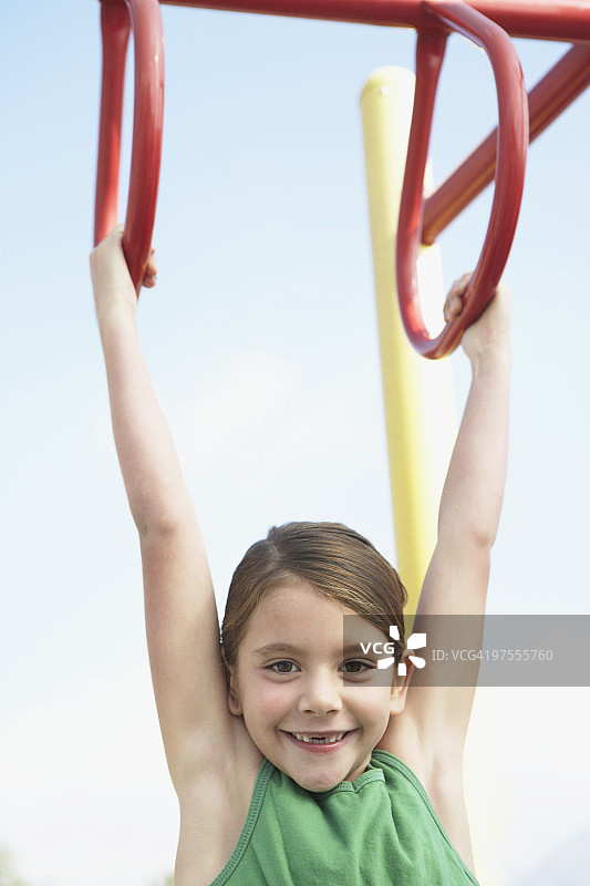 女孩在单杠上玩耍图片素材