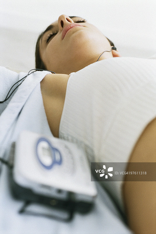 女人仰卧听随身听图片素材