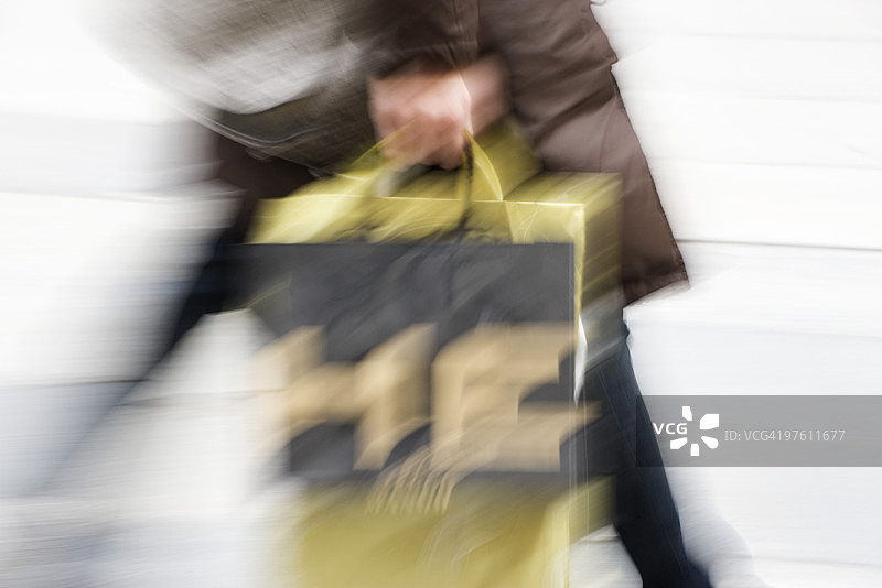手提购物袋匆忙行走的人图片素材