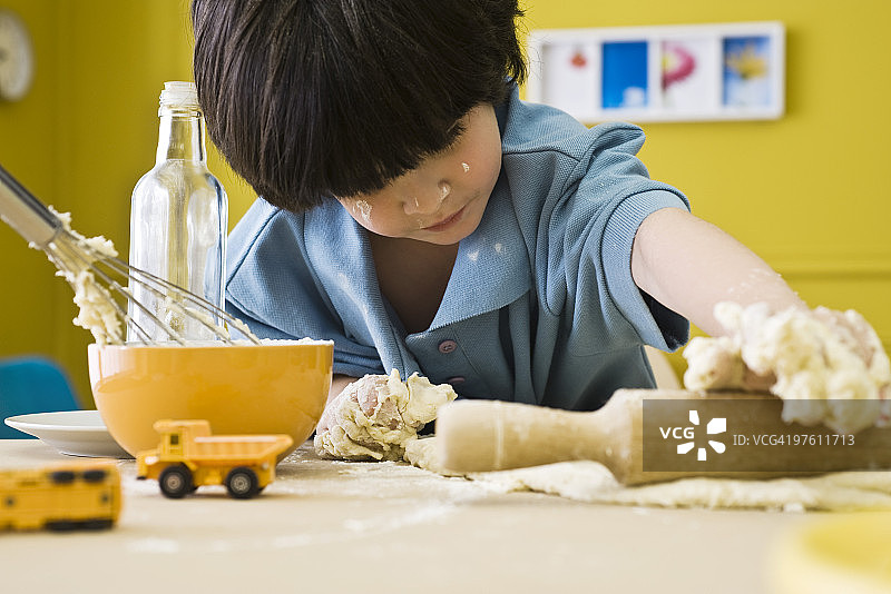小男孩用擀面杖擀面图片素材
