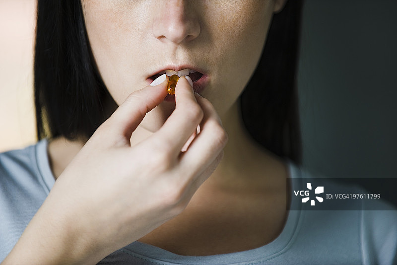 女人服用维生素，特写图片素材