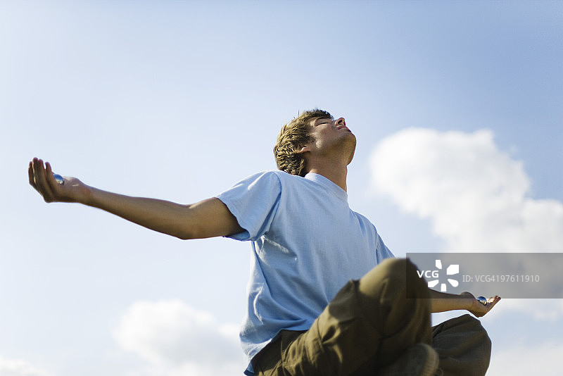 户外冥想的年轻人，手持阴阳球图片素材