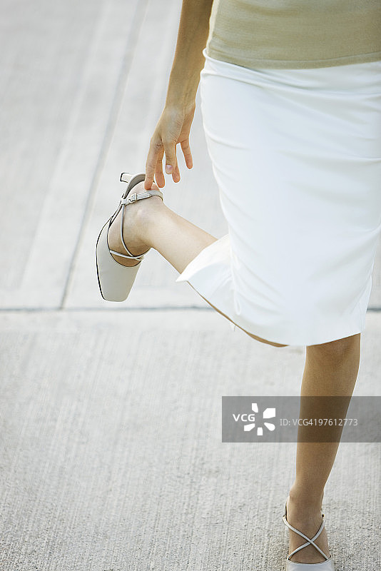 调整高跟鞋带的女人（低角度）图片素材