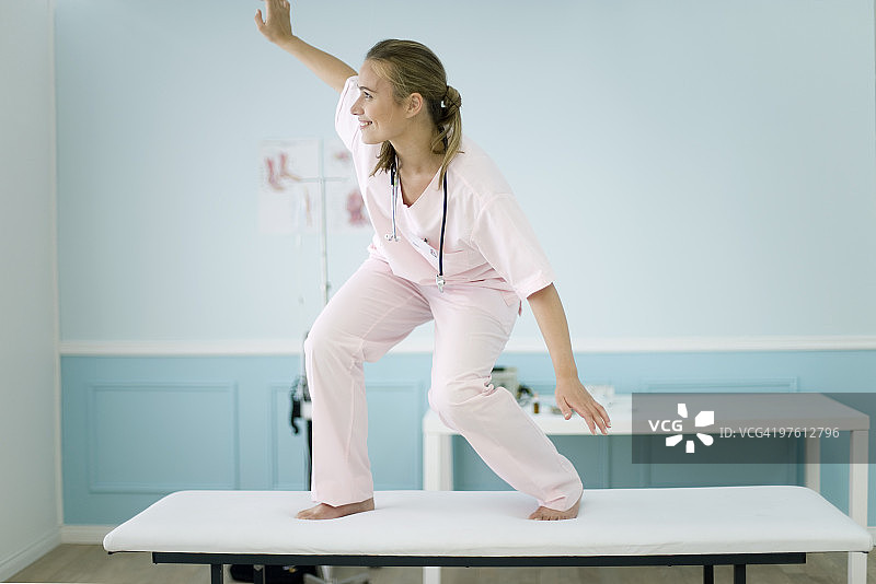 站在检查台上的女医学生假装冲浪图片素材