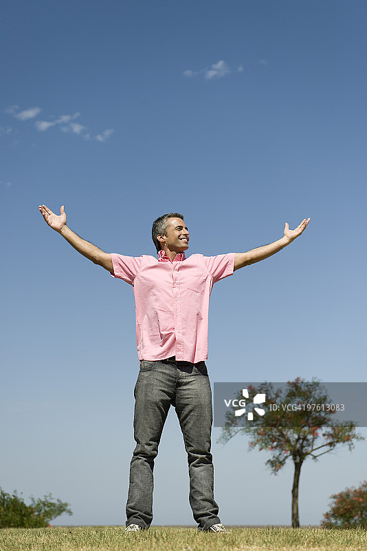 户外举起双臂的快乐男人图片素材