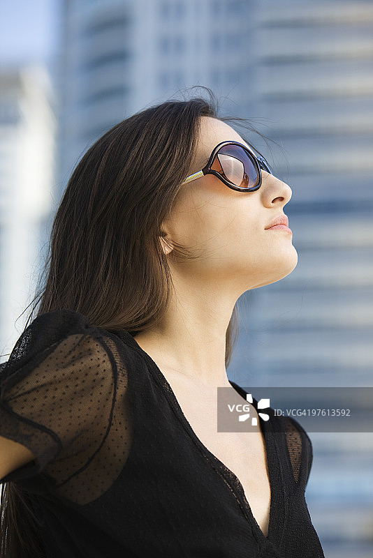 戴墨镜的女人抬头肖像图片素材