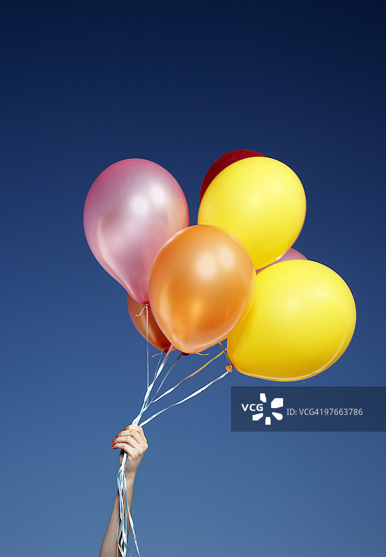 女孩手握一束气球仰望天空图片素材