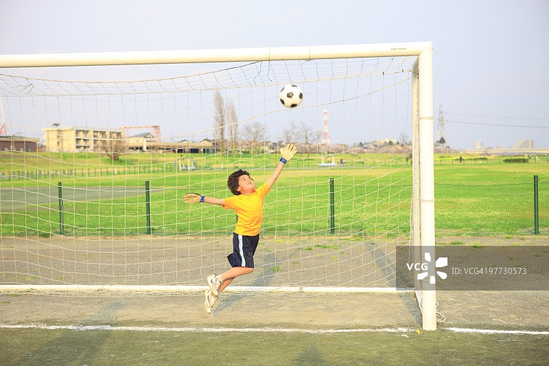 小男孩在球场上守门。日本东京世田谷区二子玉川。图片素材