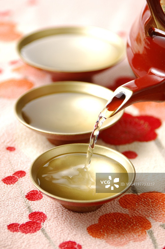 清酒倒入清酒杯，特写图片素材