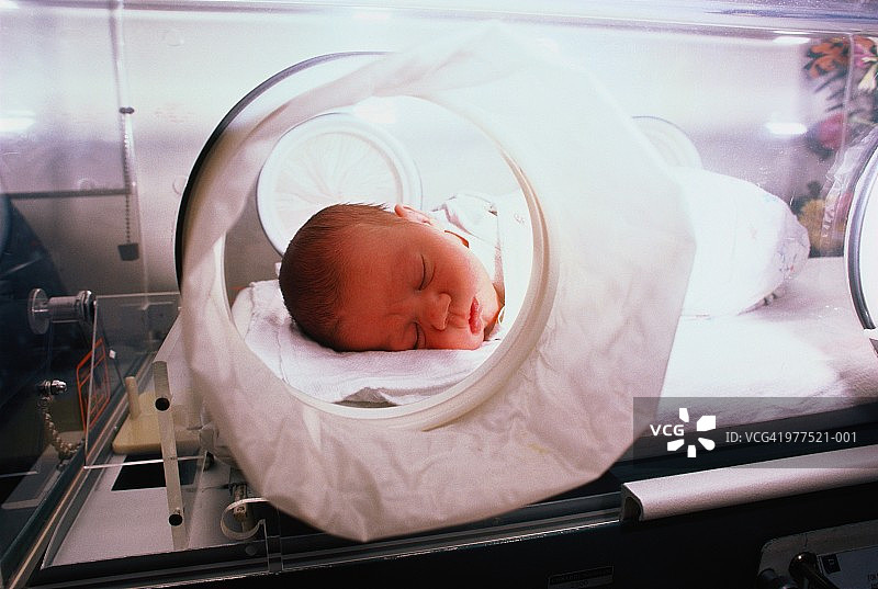 躺在保温箱里的新生婴儿图片素材