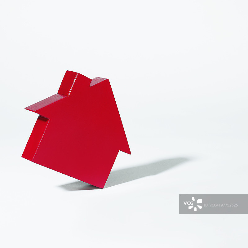 红色房屋倾倒的象征图片素材