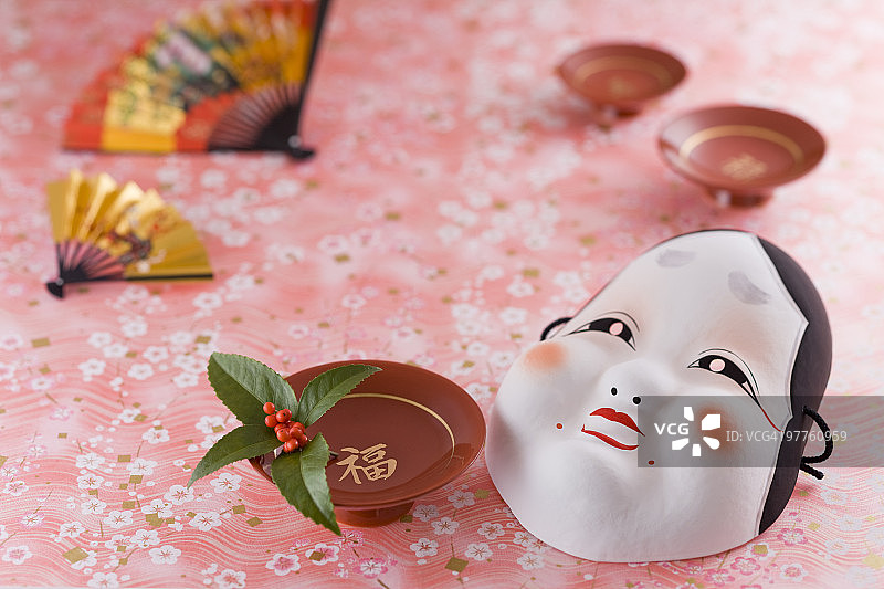 戴面具的朴素女人和清酒杯图片素材