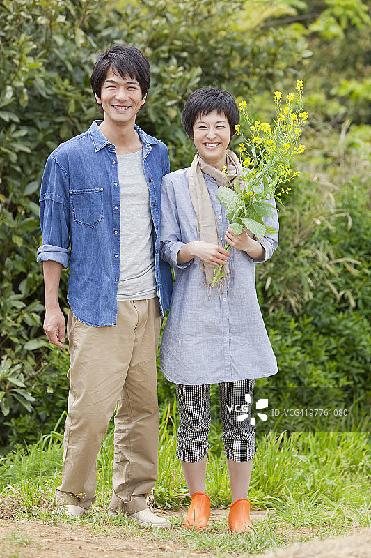 年轻情侣站在田野里图片素材