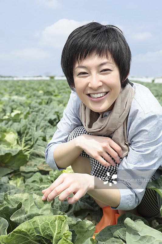 年轻女人在菜地蹲着图片素材