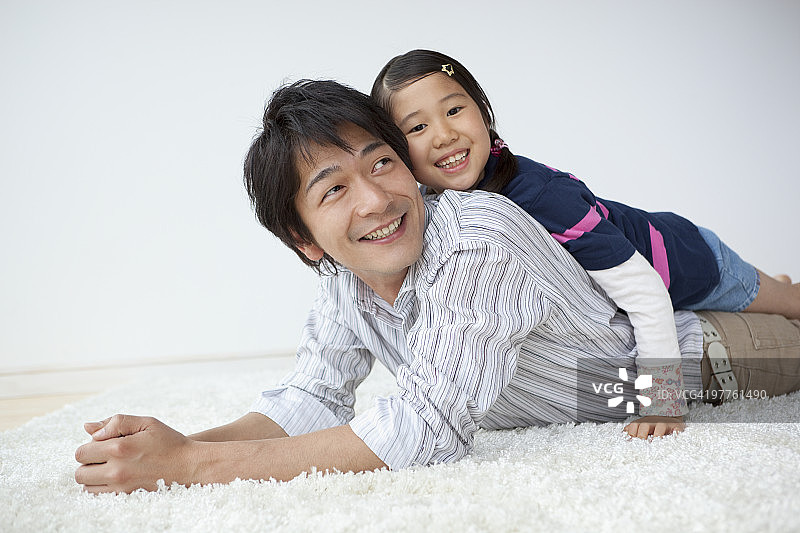 父女躺在小地毯上图片素材