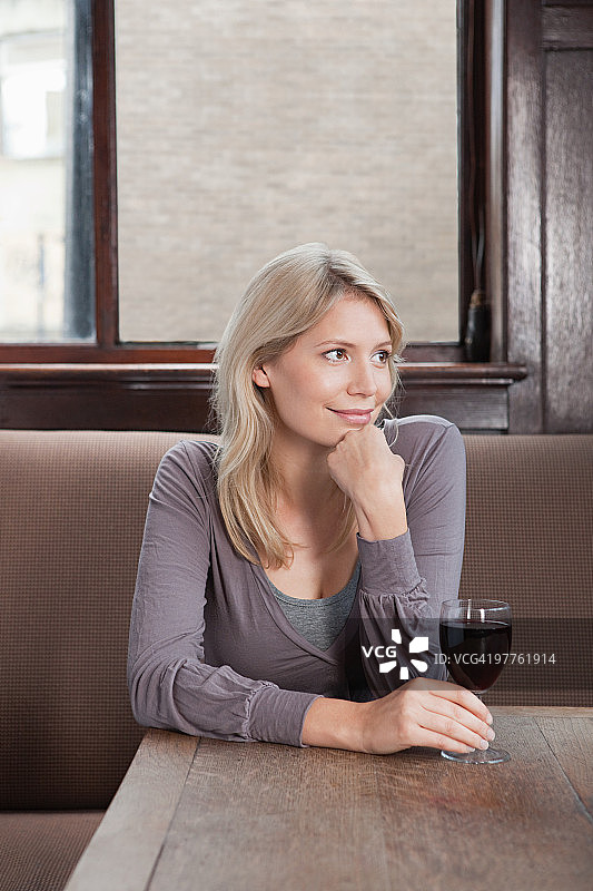 在酒吧喝红酒的年轻女人图片素材