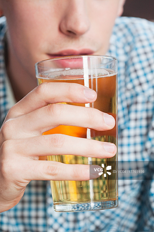 喝啤酒的年轻男人，特写图片素材