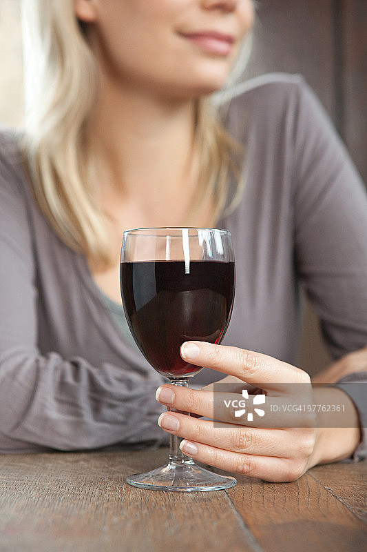在酒吧里喝红酒的年轻女人图片素材
