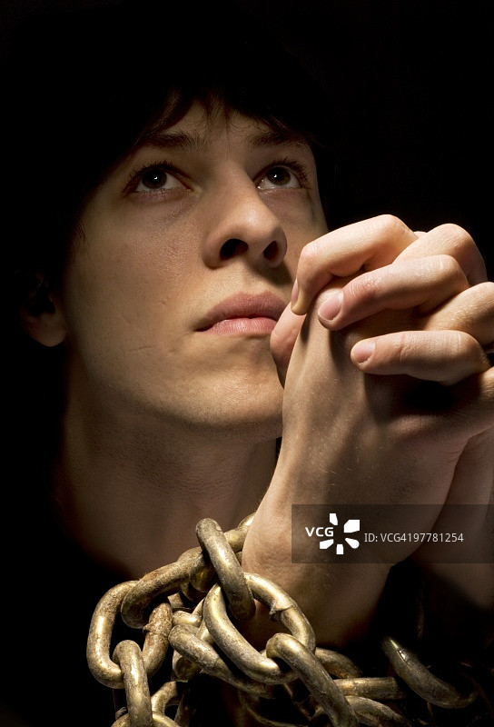 戴着锁链祈祷的男人图片素材