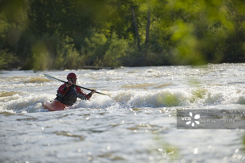一名男子在激流中玩皮划艇冲浪图片素材