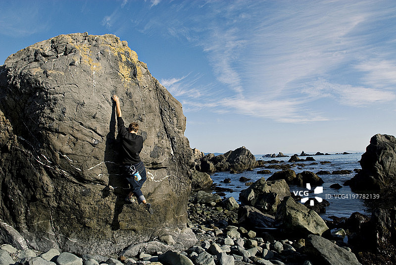一个年轻男子在加利福尼亚州新月城附近的海洋中抱石图片素材