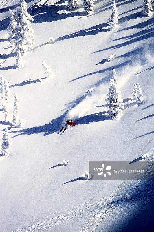 一名男滑雪者在怀俄明州大提顿后山享受蓝天粉雪图片素材