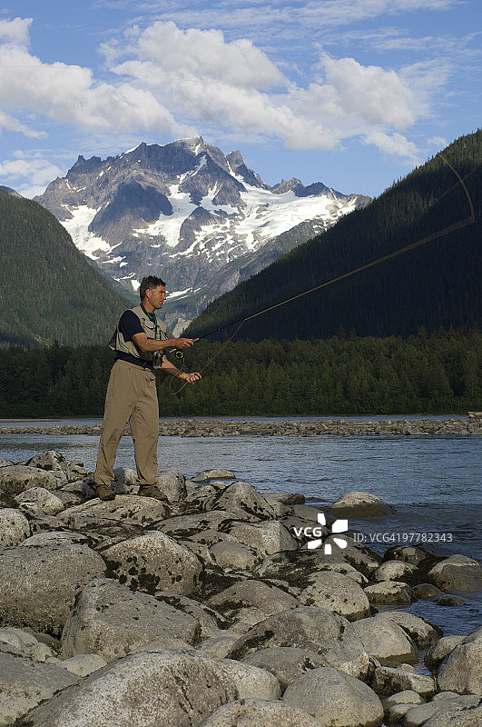 一名男子在加拿大不列颠哥伦比亚省的溪流中飞蝇钓鱼。图片素材