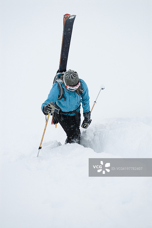 年轻女子收拾滑雪板，在加拿大的乡村小路上踢着步子图片素材