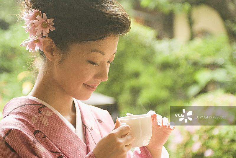 穿着和服拿着杯子的年轻女人图片素材