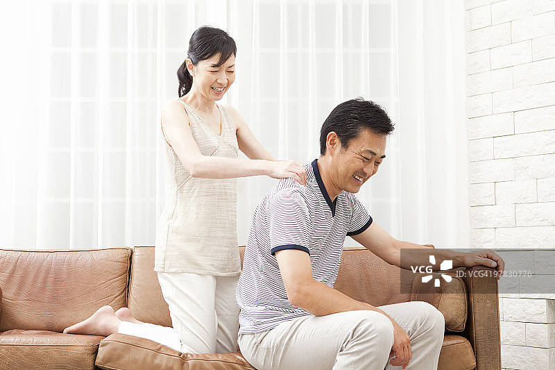 中年妇女为中年男人按摩肩膀图片素材