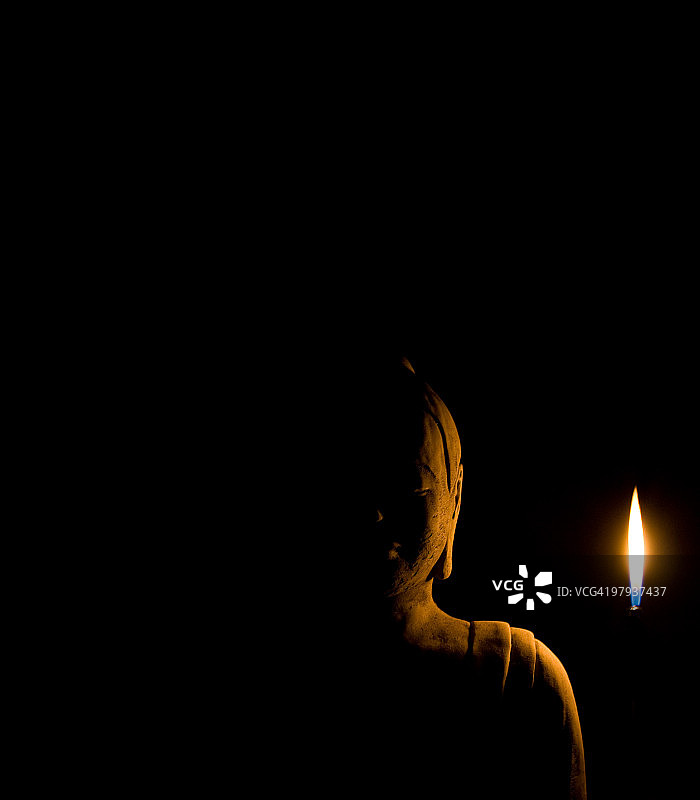 小火焰照亮的石佛像图片素材