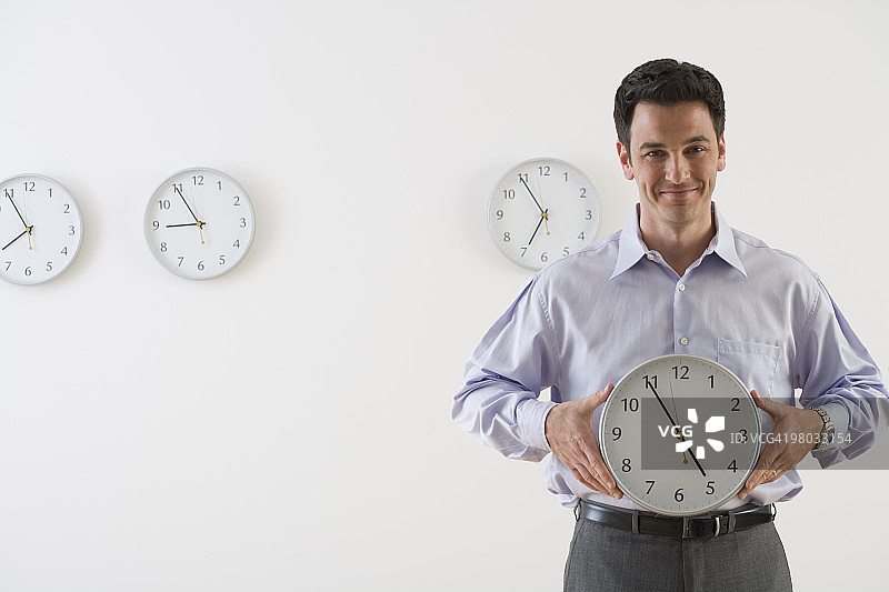 手 holding 时钟的商人图片素材