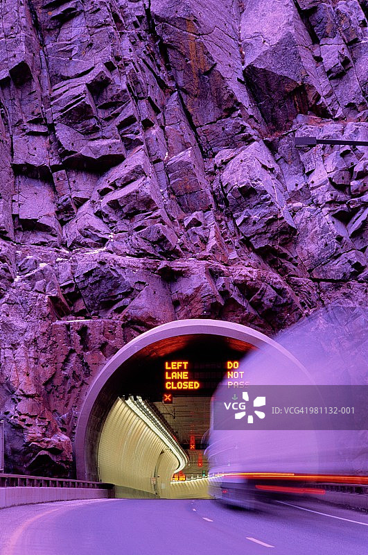 在悬崖隧道中行驶的卡车长曝光紫调图片素材