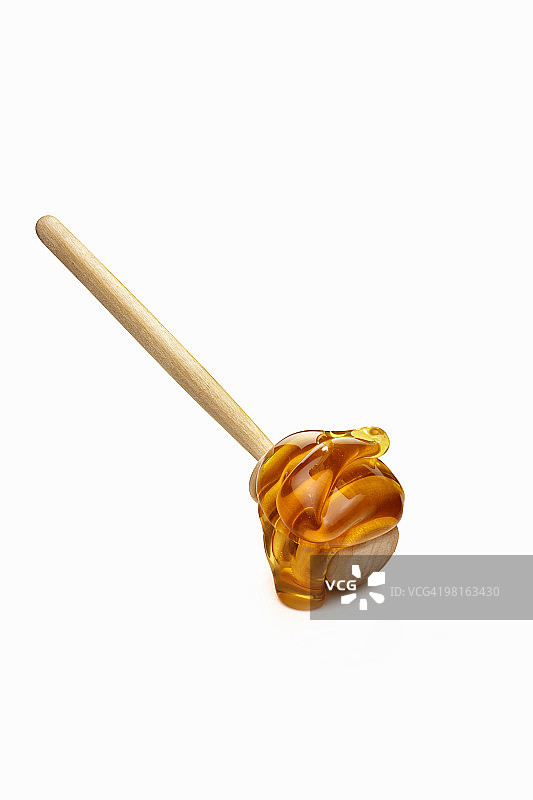 木制蜂蜜棒上的蜂蜜图片素材